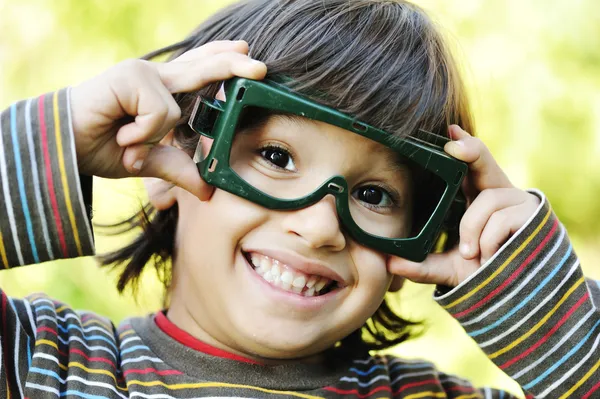 Bardzo pozytywny chłopak trzymając jego wielkie okulary i uśmiechnięty, odkryty — Zdjęcie stockowe