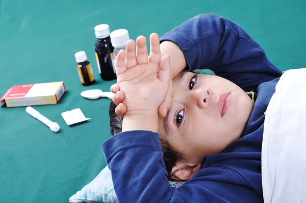 Niño enfermo con médicos y pastillas detrás de él —  Fotos de Stock