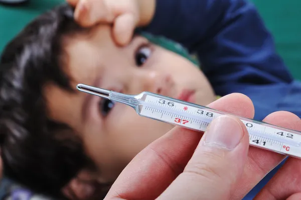 Zieke kleine jongen met thermometer in mond — Stockfoto