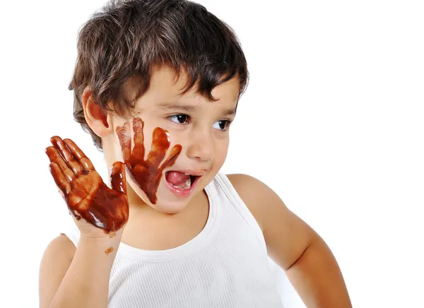 Lindo chico desordenado aislado en blanco comer chocolate — Foto de Stock