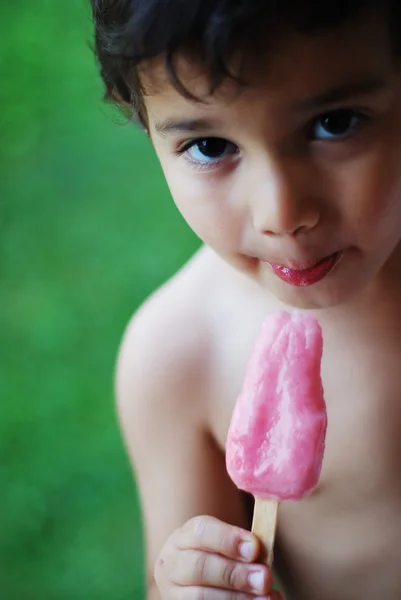 Een klein kind is een ijsje zuigen — Stockfoto