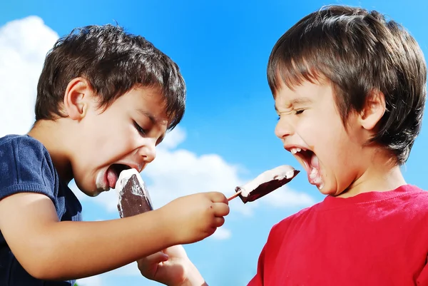 Двоє дітей годують один одного морозивом — стокове фото