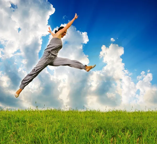 Junge sportliche Frau rennt und springt auf Wiese — Stockfoto
