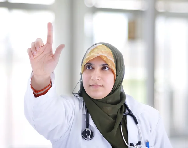 Μουσουλμανική καλύπτονται γυναίκα γιατρό που δείχνει σε ψηφιακή κουμπί στο γραφείο - μπάτσος — Φωτογραφία Αρχείου