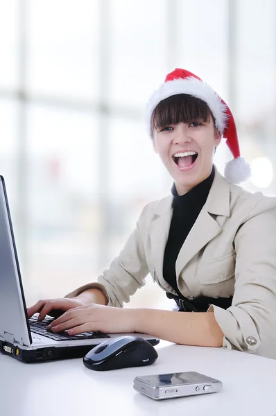 Szép nő viselt santa kalap, gazdaság Szervezõ, segítségével mobil, mosolyogva azt — Stock Fotó