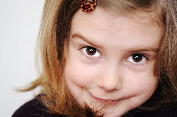Чарівна маленька дівчинка робить дурні смішні обличчя ізольовані на білому тлі — стокове фото