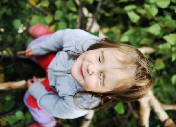 Bellezza bambino biondo su albero foglie terra con gli occhi chiusi — Foto Stock