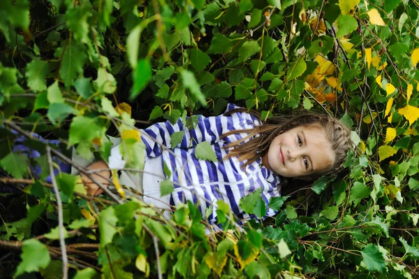 Beauty blond girl laying down on leaves ground — Stock Photo, Image