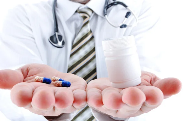 Νέος γιατρός, προσφέροντας ένα χάπι και χάπια σε μπουκάλι - σε ένα άλλο χέρι. Co — Φωτογραφία Αρχείου