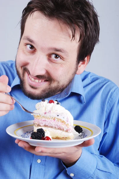 Человек ест кусок шоколадного торта — стоковое фото