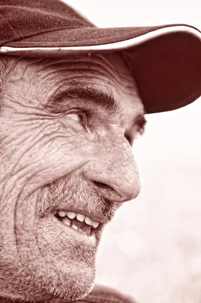 Профиль крупным планом улыбающегося старика с седой бородой — стоковое фото