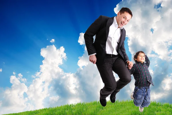 Padre e figlio che saltano all'aperto sul prato verde — Foto Stock