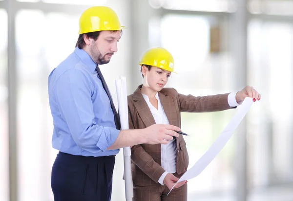 Mężczyzna i kobieta architektów na budynku budowy — Zdjęcie stockowe