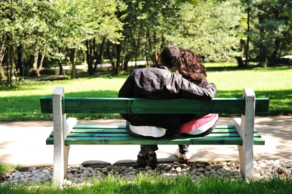 Νεαρό ζευγάρι στην αγάπη, κάθεται στη φύση σε παγκάκι: εραστές στο πάρκο — Φωτογραφία Αρχείου