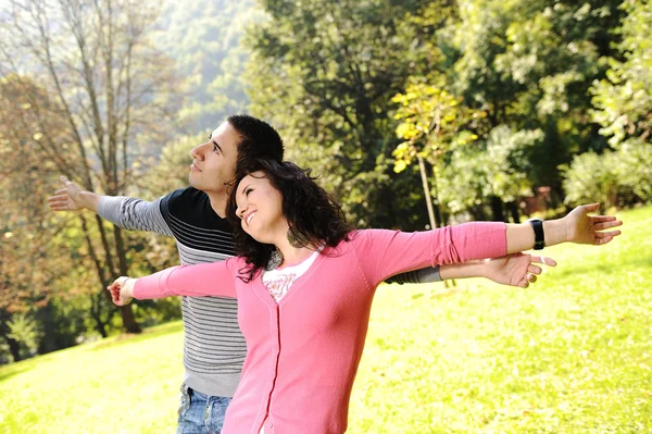 Two young relaxed in nature with opened arms looking up and breathin — Stock Photo, Image
