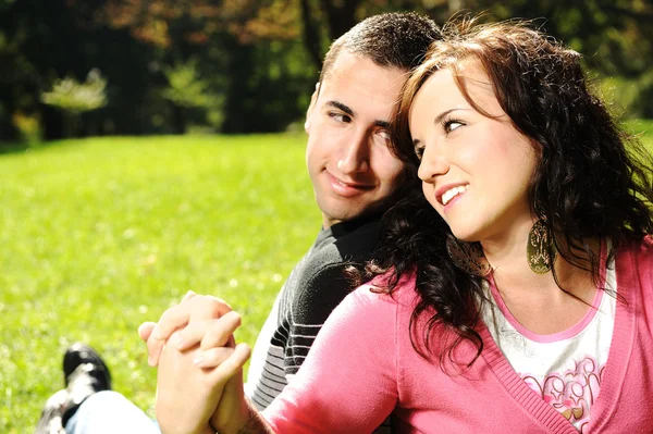 Pareja joven enamorada: amantes en el parque cogiéndose las manos y SM —  Fotos de Stock