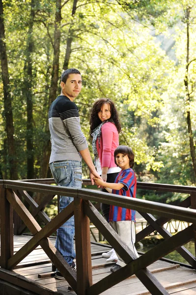 Vacker scen för unga lyckliga familjen promenader i naturen tillsammans — Stockfoto