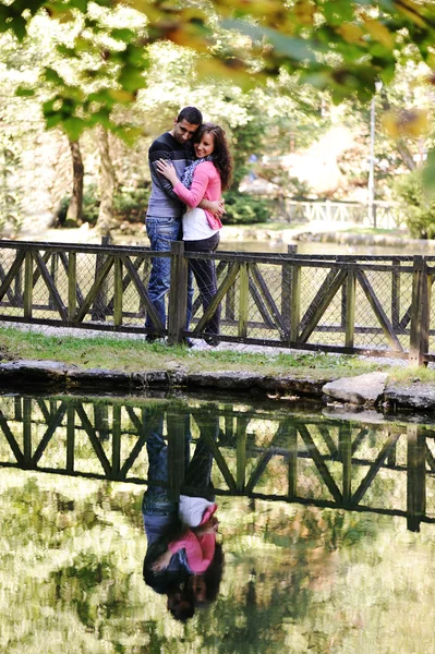 Jovem casal se amando no rio na natureza com reflexão na água — Fotografia de Stock