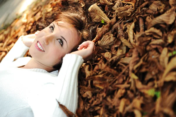 Unga skönhet flicka på hösten marken och blad, perfekta ansikte och natu — Stockfoto