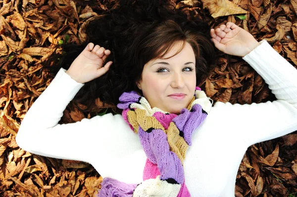 Młoda piękna dziewczyna na ziemi jesień, liście, idealną twarz i natu — Zdjęcie stockowe