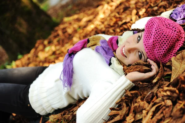 Joven chica de belleza tendida en el suelo de otoño y hojas, cara perfecta y natu —  Fotos de Stock