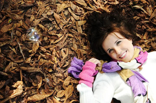ナツ完璧な顔と葉秋地面に敷設の若い美しさの少女 — ストック写真