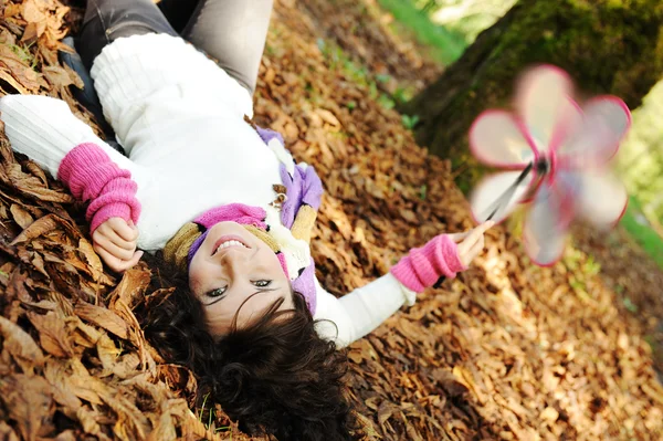 Joven chica de belleza tendida en el suelo de otoño y hojas, cara perfecta y natu —  Fotos de Stock
