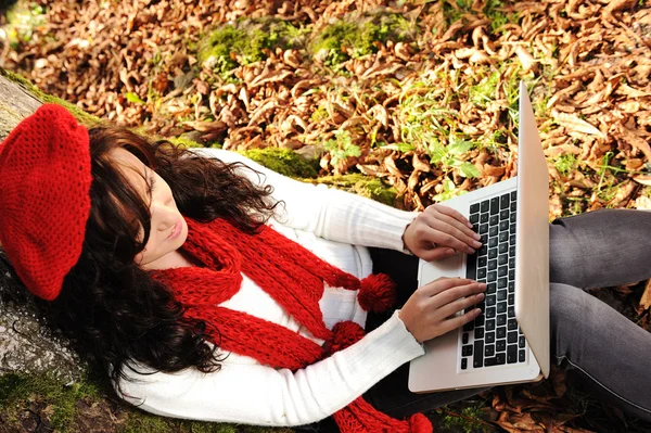 Beauty gorgeous autumn girl sitting in nature beside the tree and working o — Stock Photo, Image