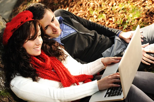 Casal jovem, masculino e feminino sentado no parque e estudando e workind toget — Fotografia de Stock