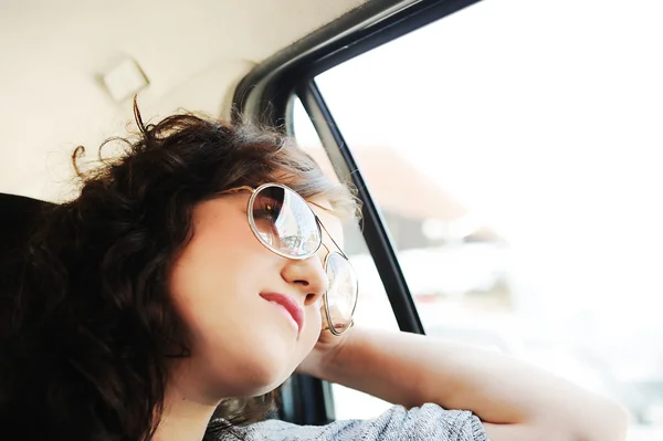 Krásná šťastná dívka v autě, hledá koryto okno — Stock fotografie
