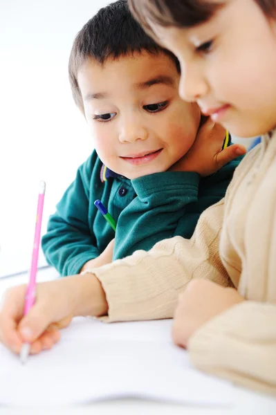 Два милых школьника вместе работают над домашним заданием — стоковое фото