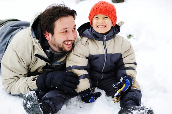 Padre e hijo jugando felizmente en la nieve, temporada de invierno —  Fotos de Stock