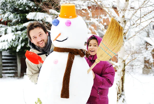 Pai e filha, pai e menina jogando jogo com o homem da neve, inverno, decem — Fotografia de Stock