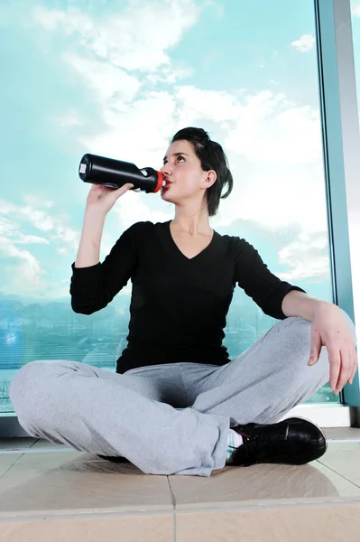 Fitness chica deportiva haciendo ejercicio y bebiendo un agua — Foto de Stock
