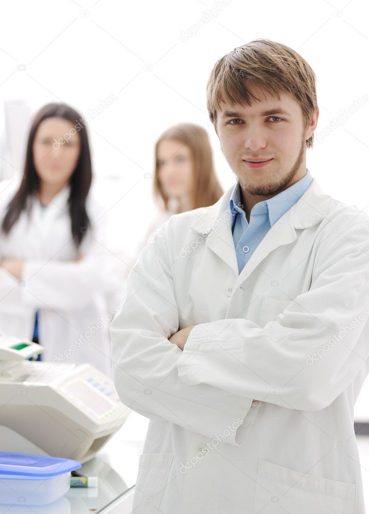 Group of scientists standing at the laboratory, young doctor with folded a