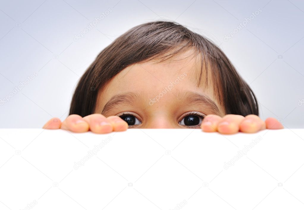 Child holding an empty sign over a white background, hiding behind