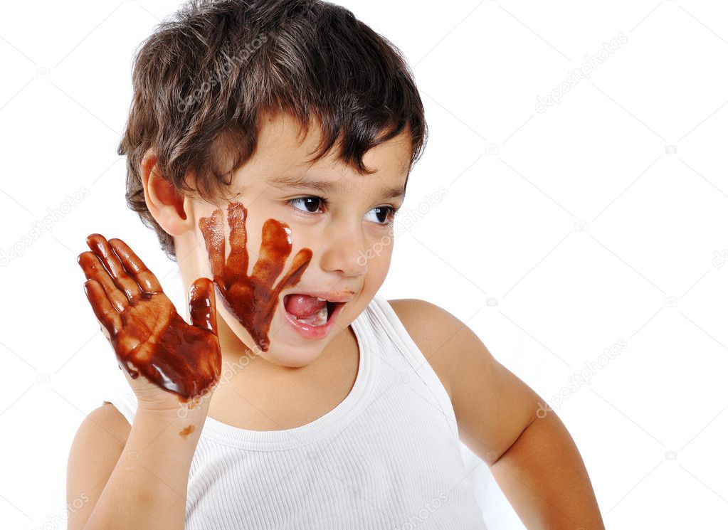 Cute messy kid isolated on white eating chocolate