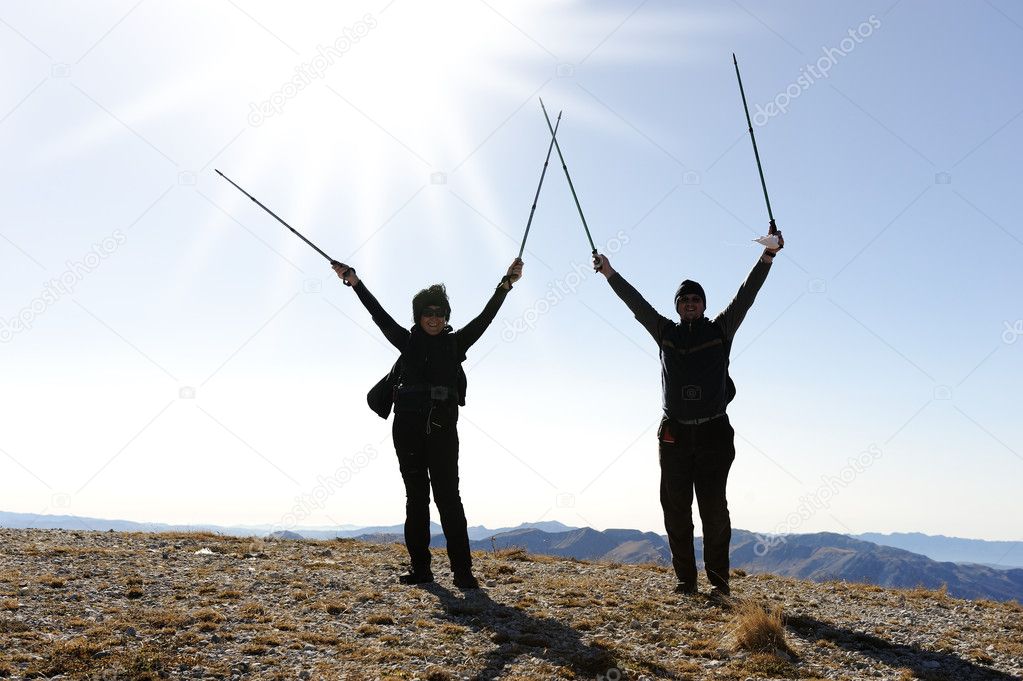 Rock-climbers on background mountain landscape with the hands stretched in