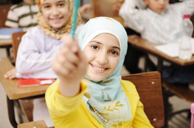 Adorable Muslim girl in classroom with her friends children students clipart