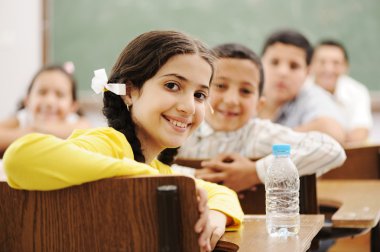 Happy cute children in classroom with their teacher clipart