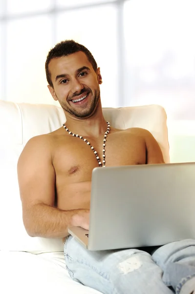 Portréja egy nyugodt fiatal srác használ a laptop otthon — Stock Fotó