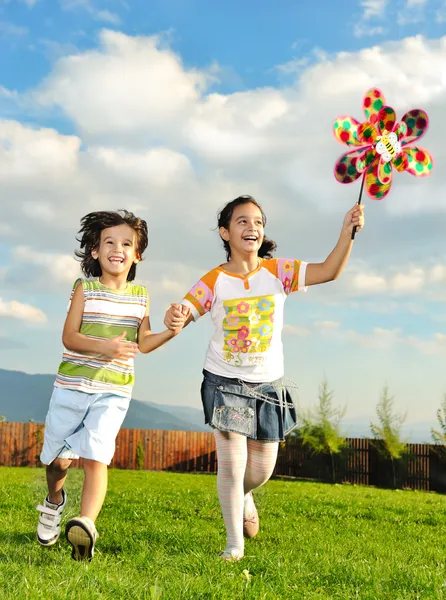 Fantástica escena de niños felices corriendo y jugando con cuidado en m verde —  Fotos de Stock