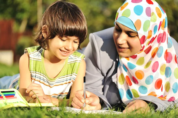 Мусульманських матері і сина мало навчання разом покладення землі — стокове фото
