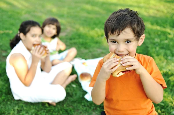 Piccolo gruppo di bambini in natura mangiare spuntini insieme, panini, pane — Foto Stock