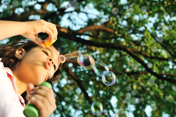 Девочка делает пузыри в природе — стоковое фото