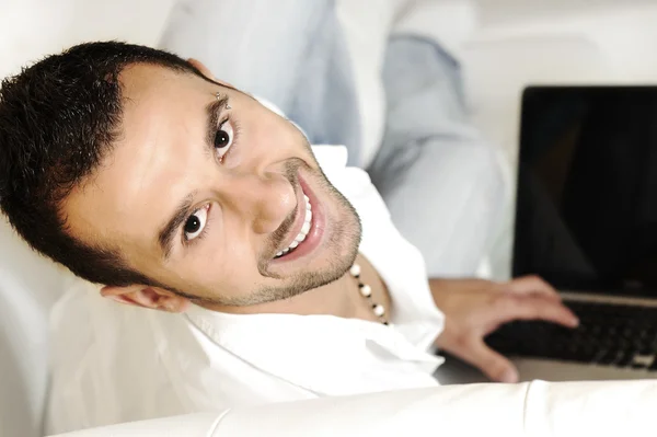 Porträt eines entspannten jungen Mannes mit Laptop zu Hause — Stockfoto