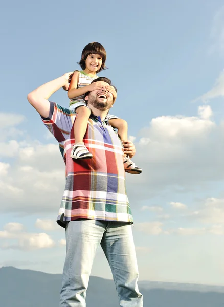 Joven padre y su hijo en la espalda, a cuestas, pikaboo jugando, escena al aire libre —  Fotos de Stock