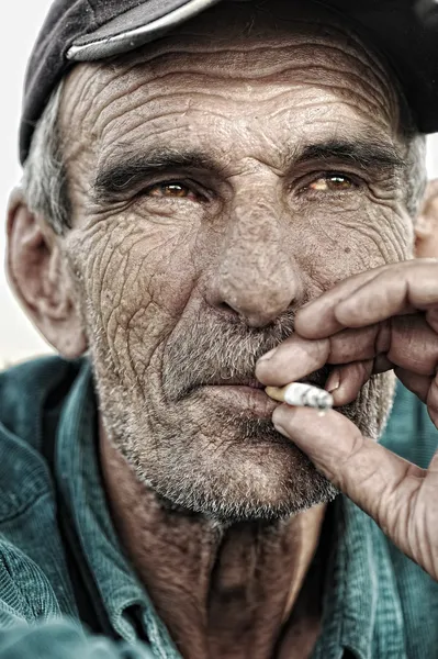 Старик курит — стоковое фото