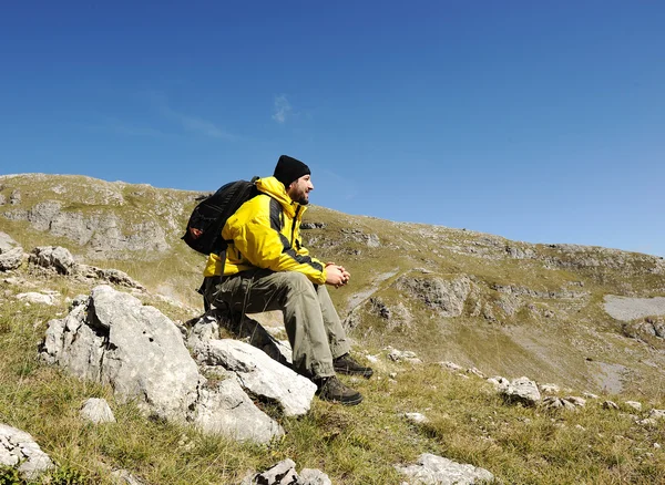 Dağın tepesinde oturan adam — Stok fotoğraf