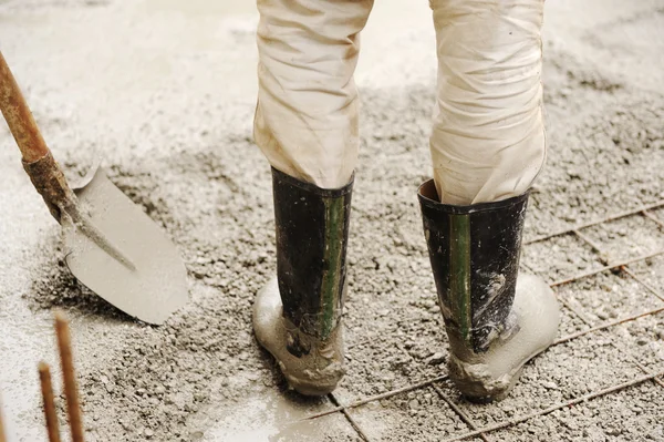 Человек выравнивает бетонную плиту, рабочее место — стоковое фото